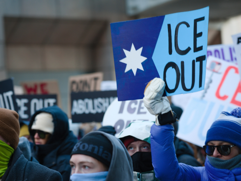 Protesters holding signs reading "ICE Out"
