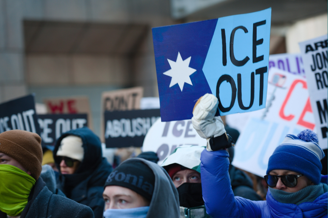 Protesters holding signs reading "ICE Out"